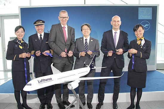  traditionelles Ribbon Cutting für den offiziellen Erstflug nach Osaka. Der japanische Generalkonsul in München, Tetsuya Kimura (4 v. l.), Wilken Bormann, CEO Lufthansa Hub München (5 v. l.), der Leiter des Bereichs Aviation bei der Flughafen München GmbH, Andreas von Puttkamer (3 v. l.) sowie Flugkapitän Thomas Jahn (2 v. l.) und die Flugbegleiterinnen Akiko Saito (rechts) und Saori Miyakawa (links) machten symbolisch den Weg für den neuen Langstreckenflug frei. (©Foto: Marikka-Laila Maisel)